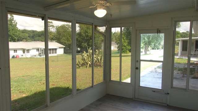 unfurnished sunroom featuring ceiling fan and a healthy amount of sunlight