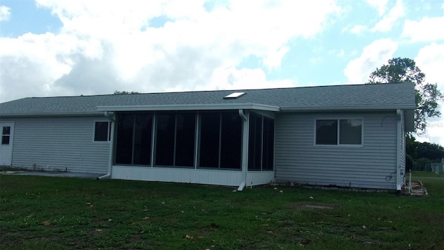 rear view of house featuring a sunroom and a yard