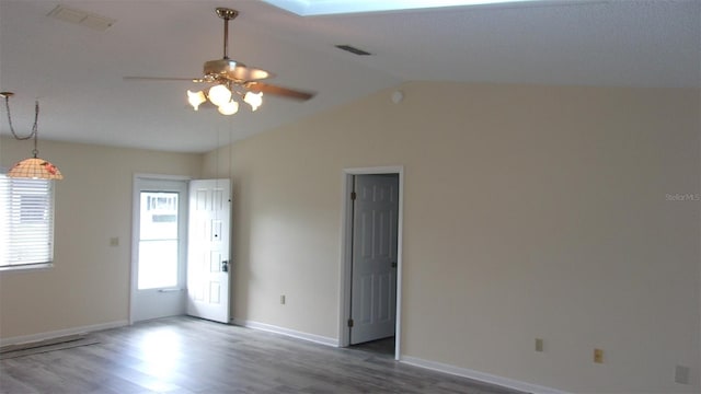 empty room with ceiling fan, wood-type flooring, and vaulted ceiling