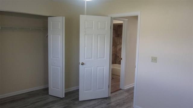 unfurnished bedroom featuring dark hardwood / wood-style floors and a closet