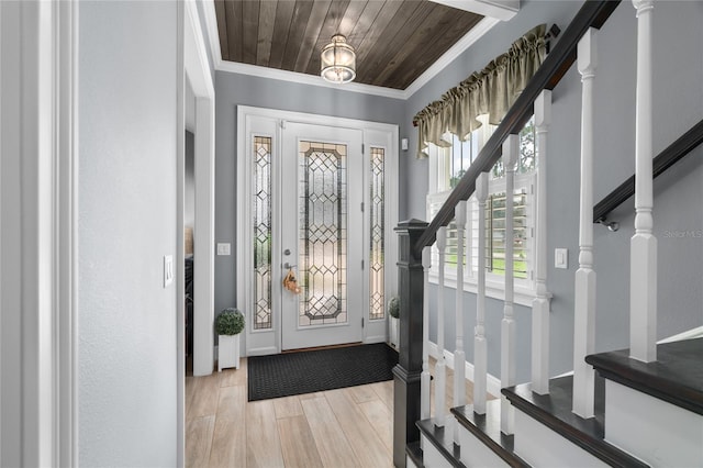 foyer featuring light hardwood / wood-style floors, crown molding, and wood ceiling