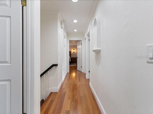 corridor with crown molding and light wood-type flooring