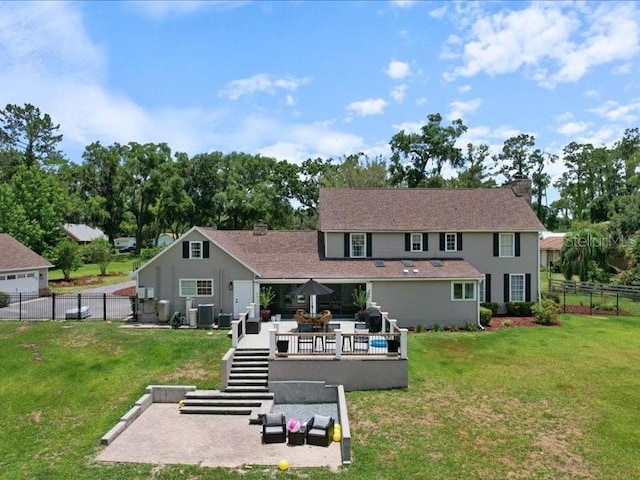 rear view of house with a lawn, cooling unit, and an outdoor hangout area