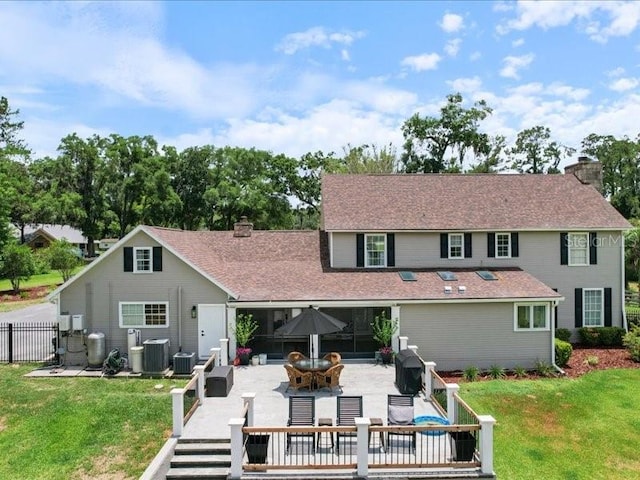 rear view of house with a yard, an outdoor hangout area, and central AC