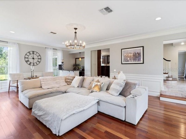 living room featuring dark hardwood / wood-style floors, an inviting chandelier, and crown molding