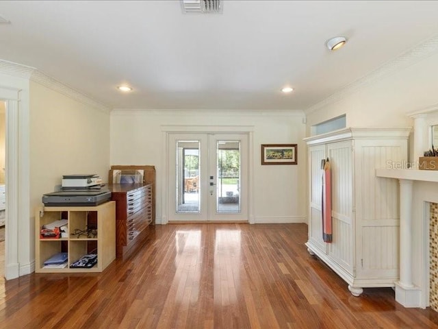 unfurnished living room featuring french doors, crown molding, and dark wood-type flooring