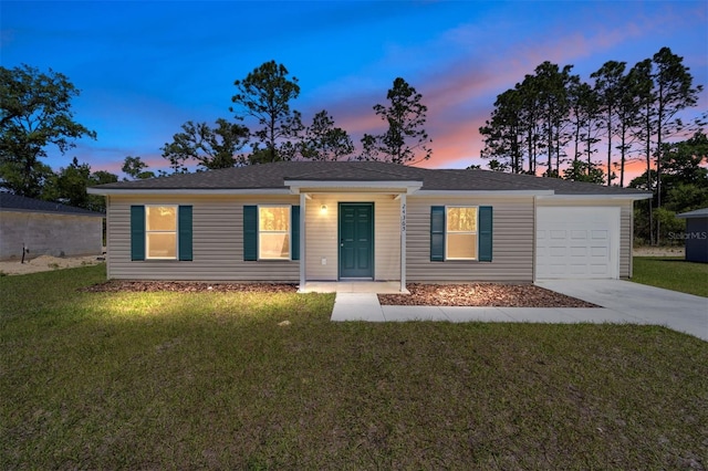 single story home featuring a garage and a yard