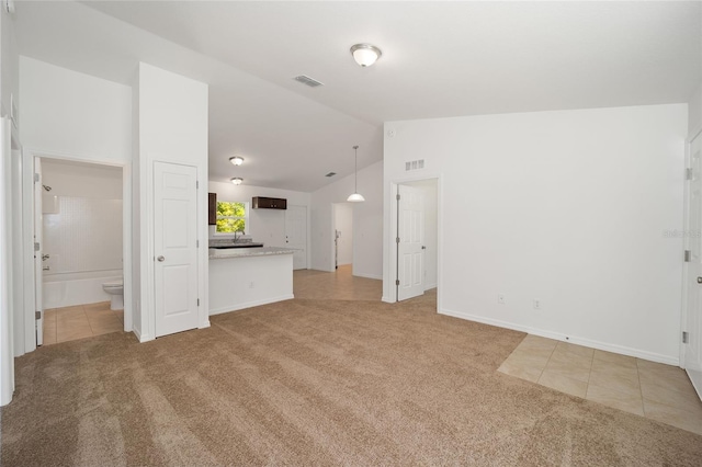 unfurnished living room with light colored carpet and vaulted ceiling