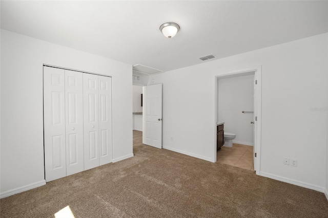 unfurnished bedroom with carpet flooring, connected bathroom, and a closet