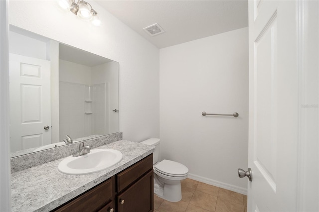 bathroom featuring tile patterned floors, vanity, toilet, and walk in shower