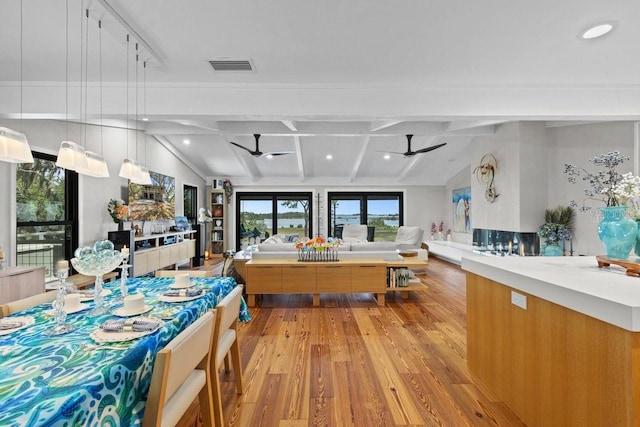 kitchen with light wood-type flooring, pendant lighting, lofted ceiling with beams, and ceiling fan