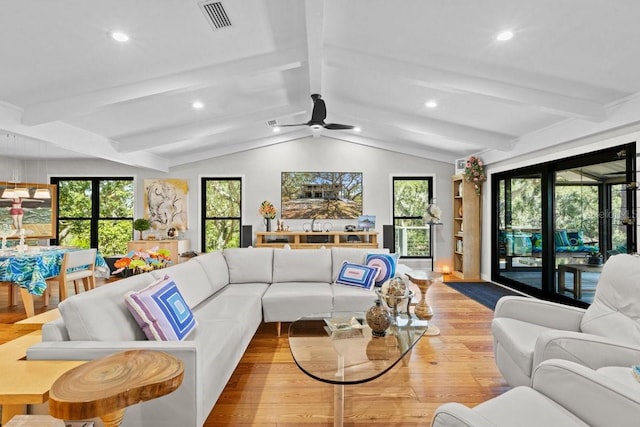 living room featuring vaulted ceiling with beams, light hardwood / wood-style floors, ceiling fan, and a healthy amount of sunlight