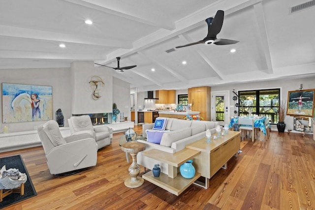 living room featuring vaulted ceiling with beams, light hardwood / wood-style floors, and ceiling fan