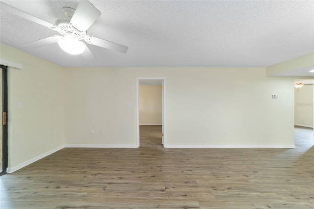 empty room with ceiling fan, light hardwood / wood-style floors, and a textured ceiling