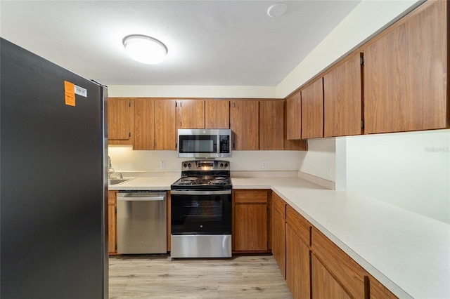 kitchen featuring light wood-type flooring and appliances with stainless steel finishes