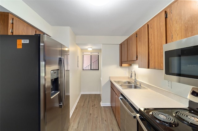 kitchen featuring stainless steel appliances, light hardwood / wood-style flooring, and sink