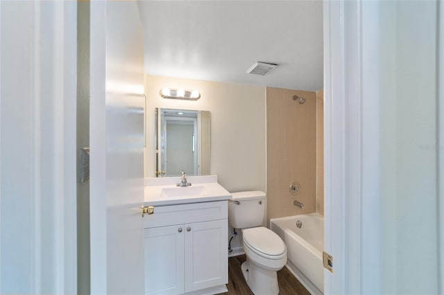 full bathroom with vanity, wood-type flooring, tiled shower / bath combo, and toilet