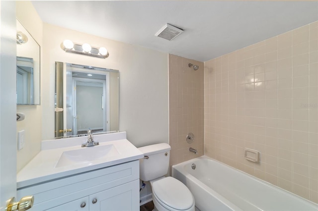 full bathroom featuring tiled shower / bath combo, toilet, and vanity