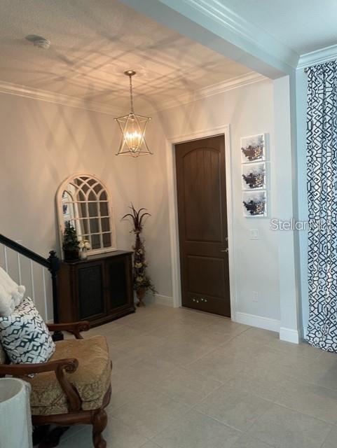 interior space with crown molding and a chandelier