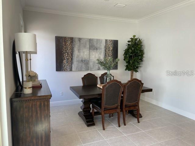 tiled dining room with ornamental molding