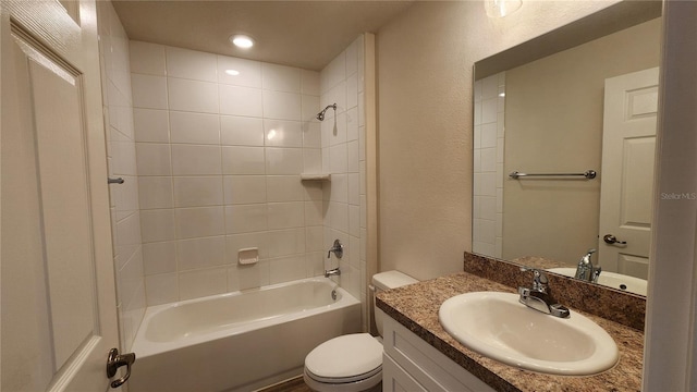 full bathroom featuring tiled shower / bath, toilet, and vanity