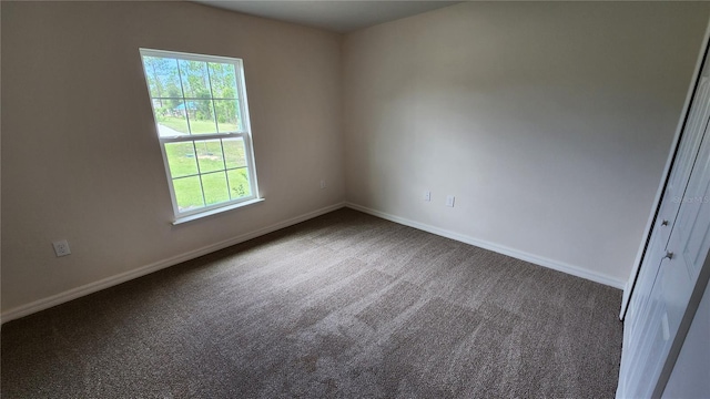 empty room featuring dark colored carpet