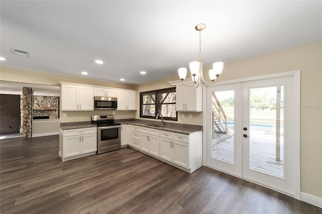 kitchen with pendant lighting, stainless steel appliances, white cabinetry, and sink