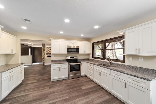 kitchen featuring white cabinets, sink, appliances with stainless steel finishes, and dark stone counters