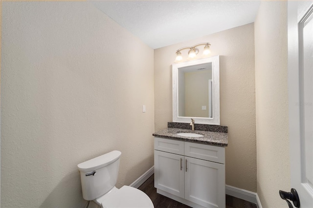 bathroom featuring wood-type flooring, vanity, and toilet