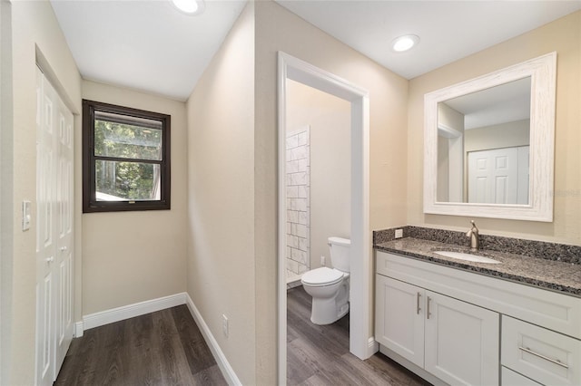 bathroom with hardwood / wood-style floors, vanity, and toilet