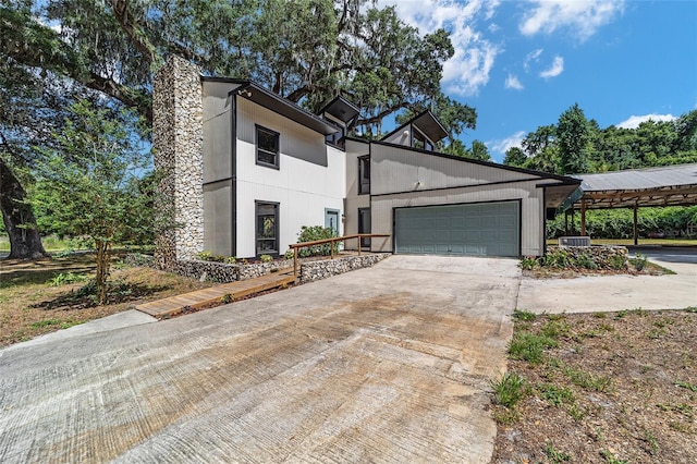 view of front facade with central AC, a carport, and a garage