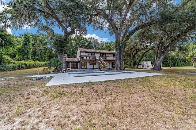 rear view of house featuring a patio and a lawn