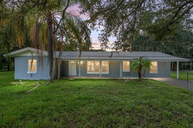 ranch-style house featuring a lawn and a carport