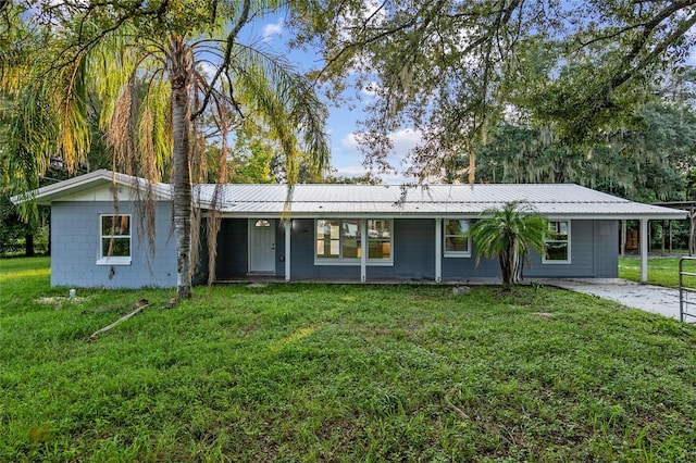 ranch-style house featuring a front lawn and a carport