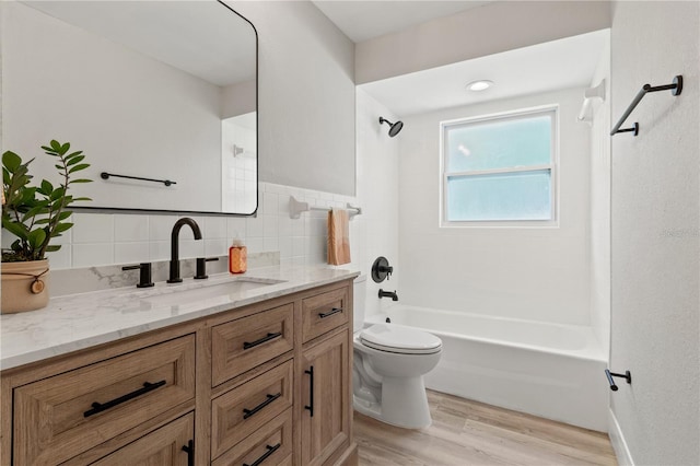 full bathroom with toilet, shower / bath combination, backsplash, wood-type flooring, and vanity