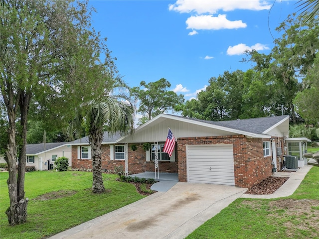 single story home featuring central AC unit, a front yard, and a garage