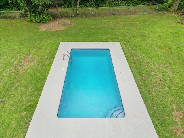 view of swimming pool with a lawn