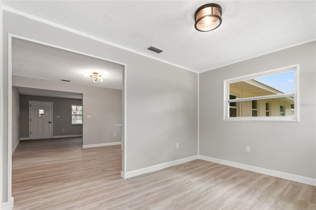 unfurnished room with a textured ceiling and light hardwood / wood-style flooring