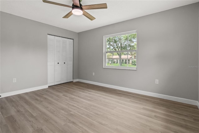 unfurnished bedroom with ceiling fan, light hardwood / wood-style floors, and a closet