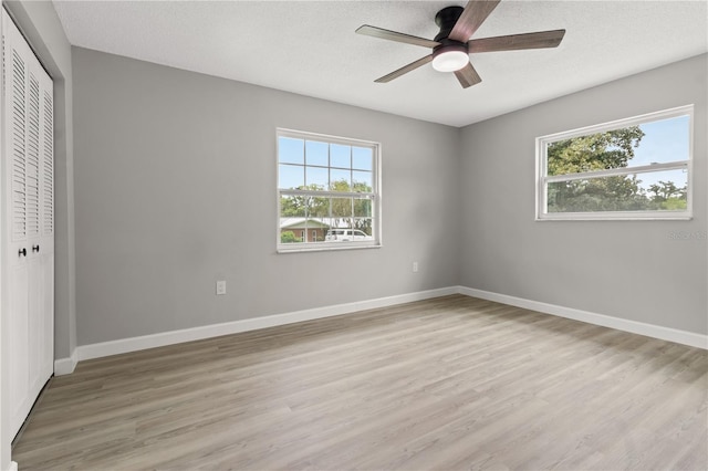 unfurnished bedroom featuring ceiling fan, a closet, and multiple windows