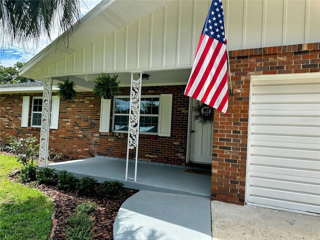 view of exterior entry featuring a porch and a garage