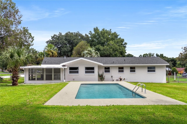 rear view of house featuring a patio, a sunroom, and a lawn