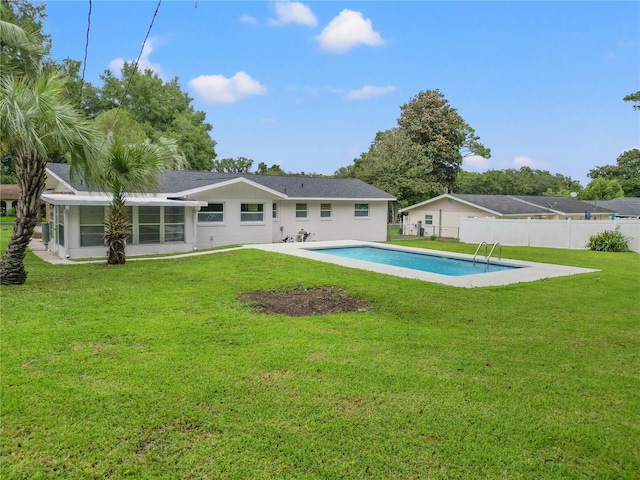 back of house featuring a fenced in pool, a patio area, and a lawn