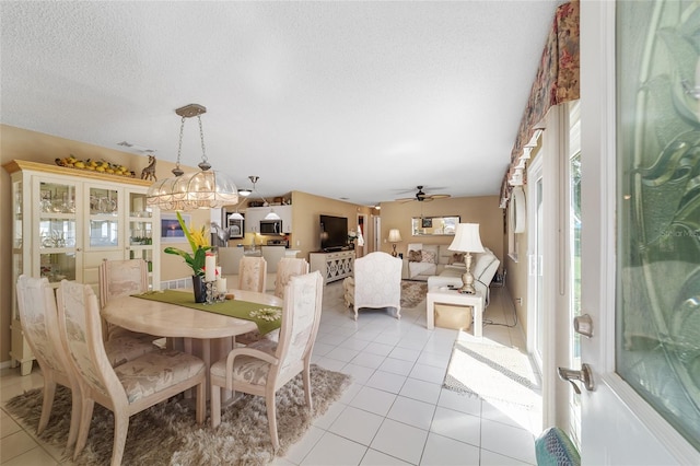 tiled dining space featuring ceiling fan and a textured ceiling