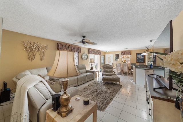 living room featuring ceiling fan, light tile patterned floors, and a textured ceiling