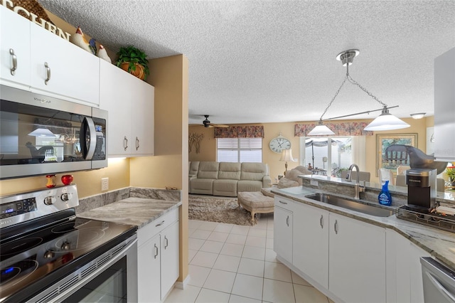 kitchen featuring white cabinetry, sink, ceiling fan, hanging light fixtures, and appliances with stainless steel finishes