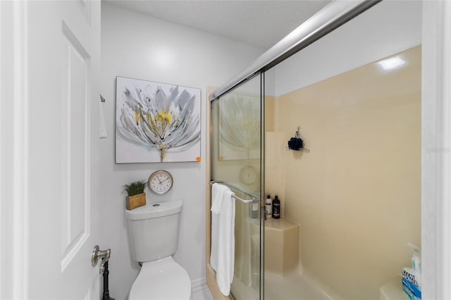 bathroom with toilet and an enclosed shower