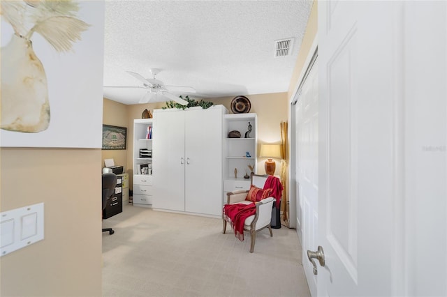 sitting room featuring ceiling fan and a textured ceiling