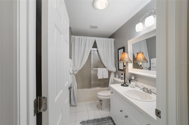 full bathroom featuring vanity, bath / shower combo with glass door, tile patterned flooring, toilet, and a textured ceiling