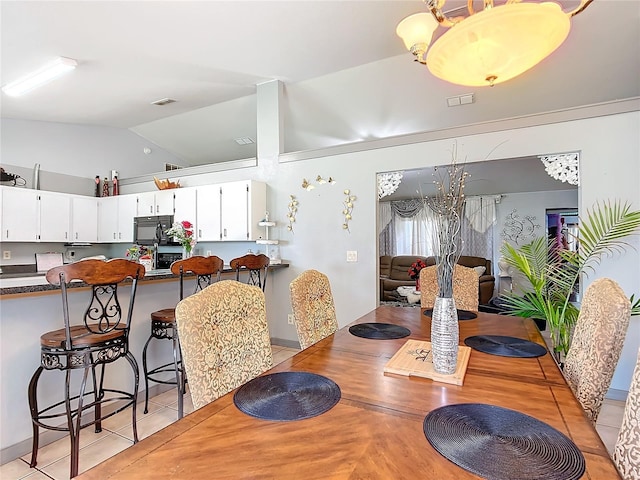 dining room with lofted ceiling and light tile patterned floors